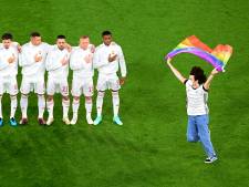Un activiste sur le terrain avec un drapeau arc-en-ciel pendant l’hymne hongrois