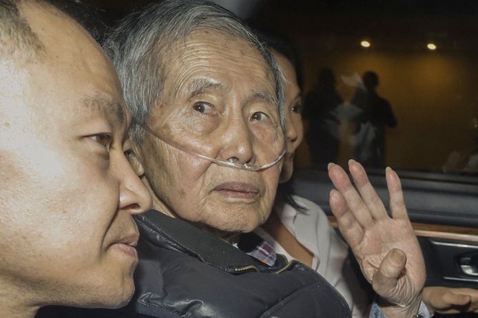 De Peruaanse oud-president Alberto Fujimori zit tussen zijn kinderen Kenji en Keiko terwijl hij na zijn vrijlating wordt weggereden.