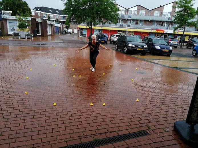 Marja ten Berge met badeendjes in een waterplas op het Wierdense Binnenhof.