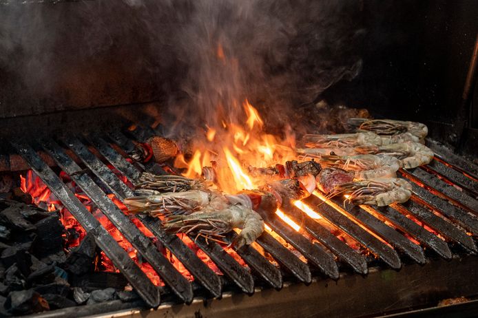 De ossenhaas in het midden ingeklemd tussen de gamba's op een loeihete grill met houtskool.