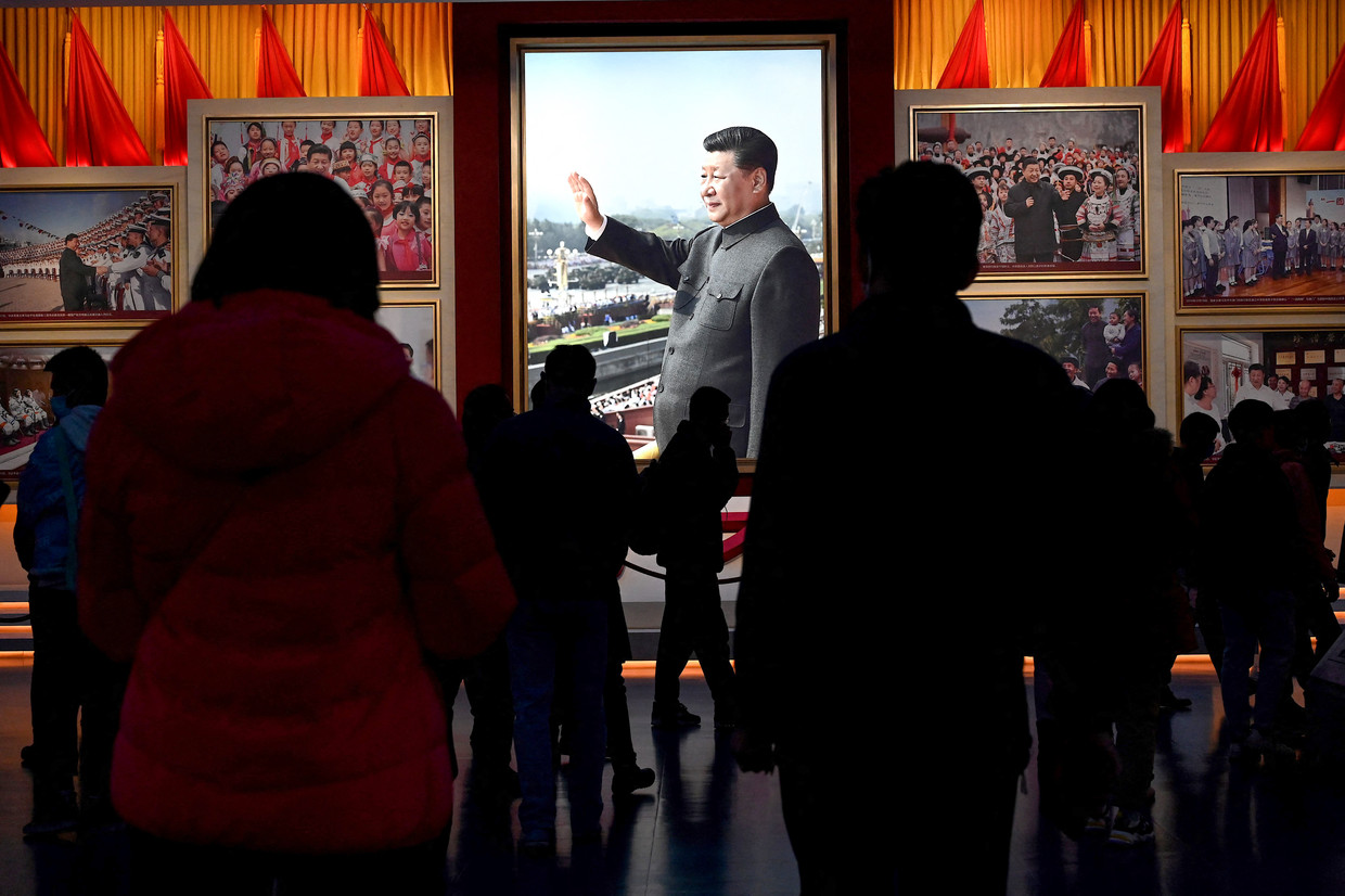 Bezoekers van het CCP-museum in Beijing bekijken een foto van president Xi.
 Beeld Noel Celis / AFP