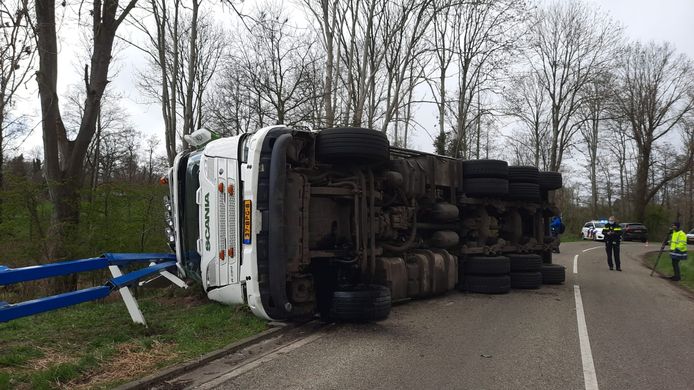 Door nog onbekende oorzaak kwam de vrachtwagen op z'n kant terecht.