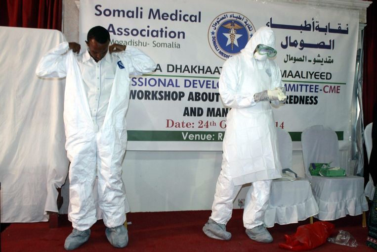 Somalische hulpverleners laten zien hoe een ebola-pak aan te trekken. Beeld epa