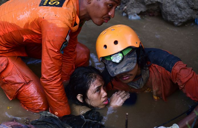 Reddingswerkers redden een vijftienjarig meisje uit haar ondergelopen huis.
