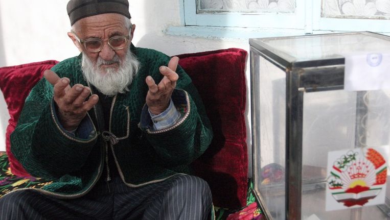 Een oudere man bidt voordat hij zijn stem uitbrengt bij de Tadzjiekse verkiezingen vorig jaar. Beeld epa
