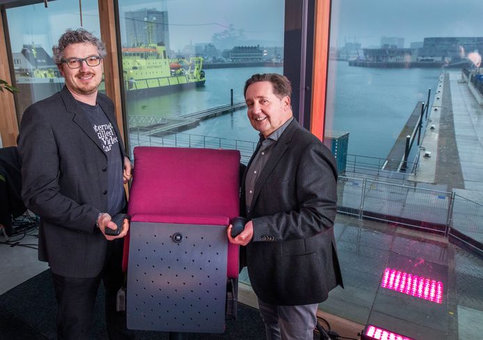 Wethouder Arjen Kapteijns van Den Haag (links) overhandigt zijn Osse evenknie Dolf Warris symbolisch een theaterstoel.