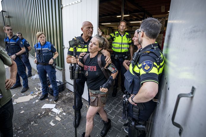 Steunbetuigers worden via de achteringang uit de supermarkt gehaald door de politie.