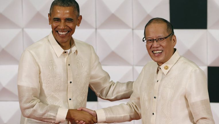 Obama, in een traditioneel Filipijns baronghemd, schudt de hand van de Filipijnse president Benigno Aquino op het galadiner van de Asia-Pacific Economic Cooperation. Beeld REUTERS