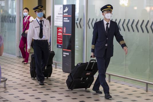 Piloten met mondmaskers op de Australische Brisbane International Airport.
