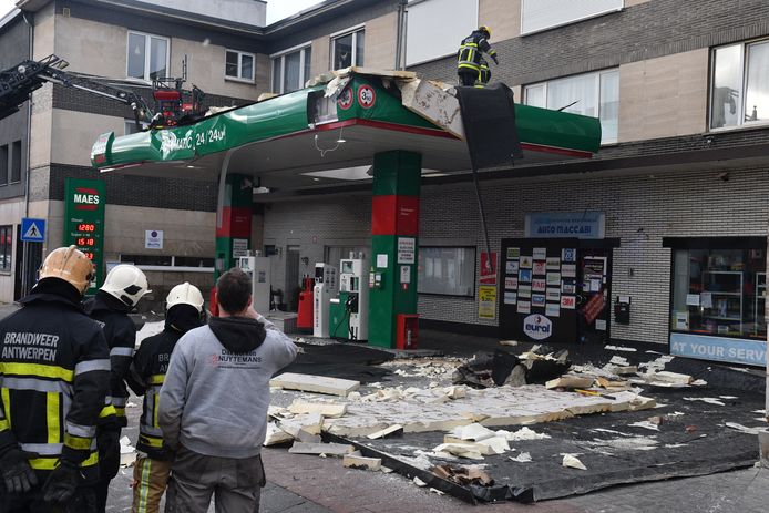 Brandweermannen meten de schade op aan een tankstation in Hoboken.