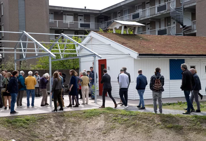 Mensen staan tijdens de opening voor de herbouwde fietsenschuur van 't Rondeel