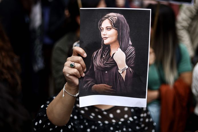 Archiefbeeld. Een vrouw houdt een portret van de Iraanse Mahsa Amini omhoog tijdens een protest.