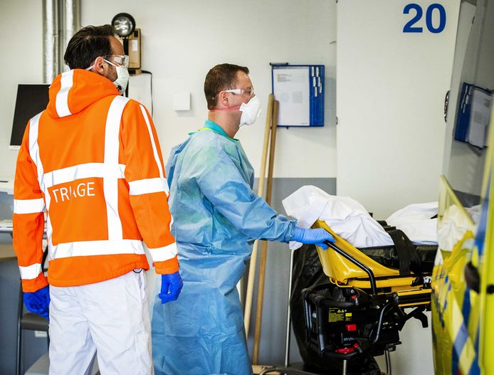 Een ambulancemedewerker brengt een coronapatient binnen op een Nederlandse spoeddienst.