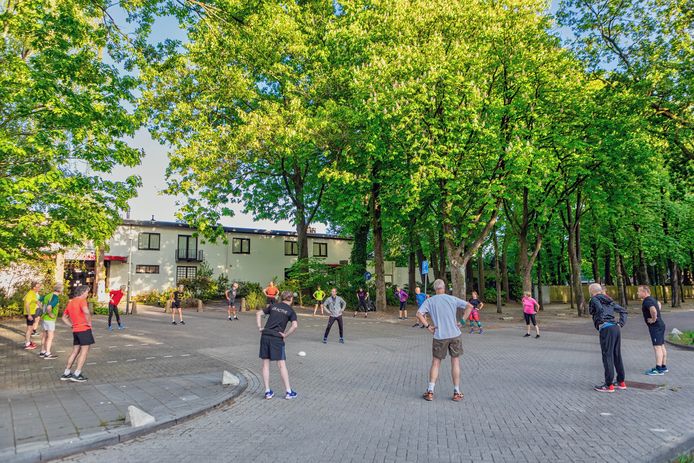 Warming-up voor Trimgroep 9 van de Oosterhoutse atletiekvereniging Scorpio, op de parkeerplaats die de startplek van hun trainingsloop is. De eerste sinds het begin van de intelligente lockdown in Nederland. ,,Langzaamaan hebben we toch ook weer behoefte aan sociale contacten. Daarom vind ik dat dit nu kan."