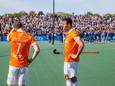 Roel Bovendeert (links) en Glenn Schuurman treuren nadat ze met Bloemendaal naast het landskampioenschap hebben gegrepen, op de achtergrond viert Pinoké feest.