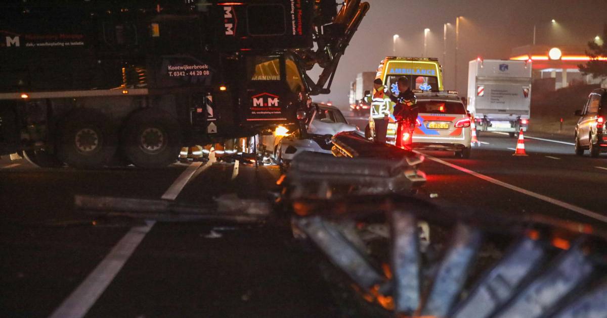 Ernstig ongeluk op A1: Hijskraan schiet door vangrail en ramt auto, bestuurster raakt gewond.