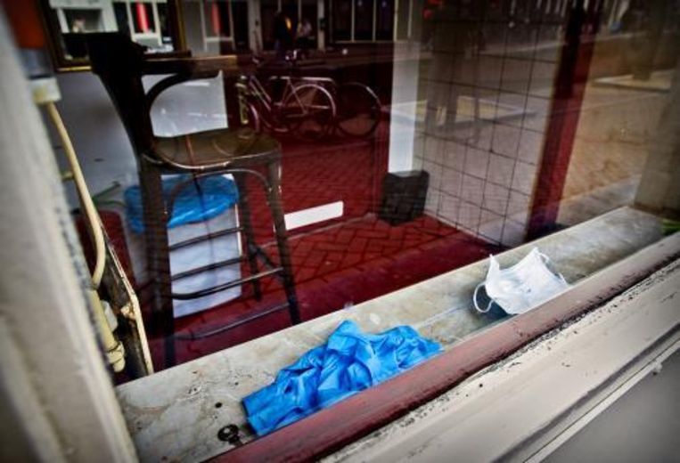 Een mondkapje en handschoenen van de recherche liggen in de peeskamer aan de Oudezijds Achterburgwal in Amsterdam waar in de nacht van donderdag op vrijdag een 19-jarige prostituee werd doodgestoken. Foto ANP Beeld 