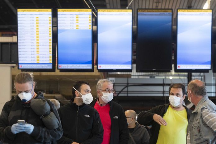 Reizigers bij de vertrekborden op Schiphol.