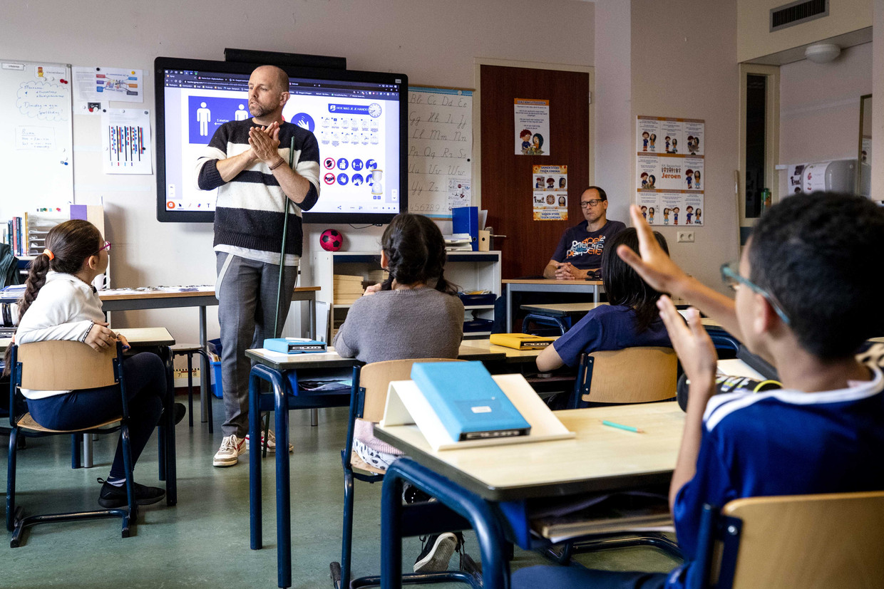Een leerkracht op een basisschool in Den Haag laat in juni 2020 na een periode van sluiting zijn klas zien hoe je je handen goed wast.  Beeld  Sem van der Wal / ANP