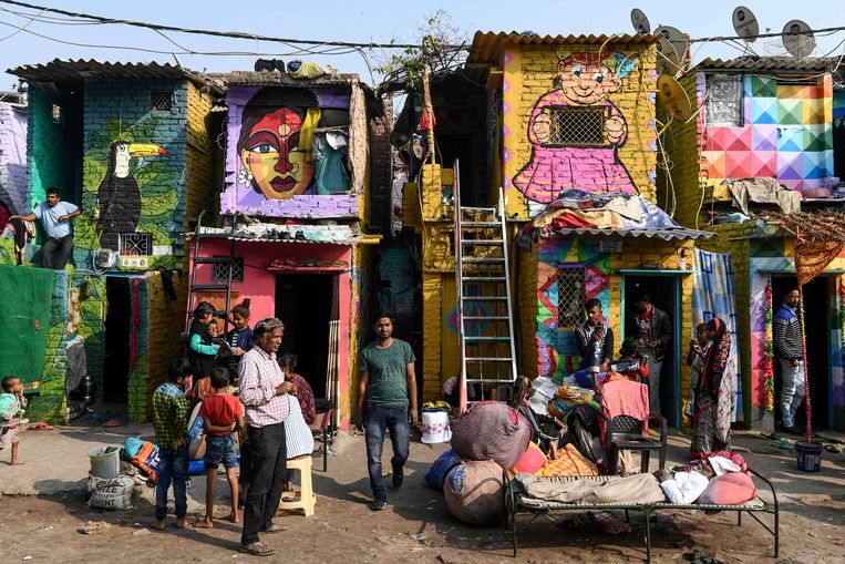 Deze muurschilderingen zijn een afspiegeling  van de natuur en het leven van de bewoners in deze sloppenwijk in New Delhi. Ze zijn gemaakt door vijftien tot twintig artiesten van de Delhi Art Street. Beeld AFP