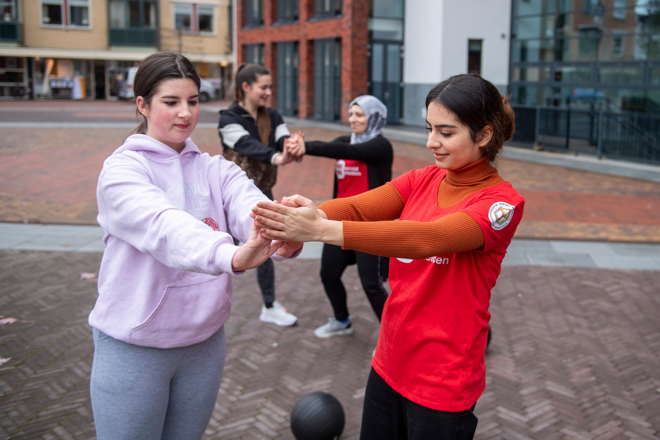 Romany (links) uit Holten loopt stage bij Wereldmeiden en sport samen met de 22-jarige Rojda (rechts). Achter haar doen Tara en Reem de sportoefening.