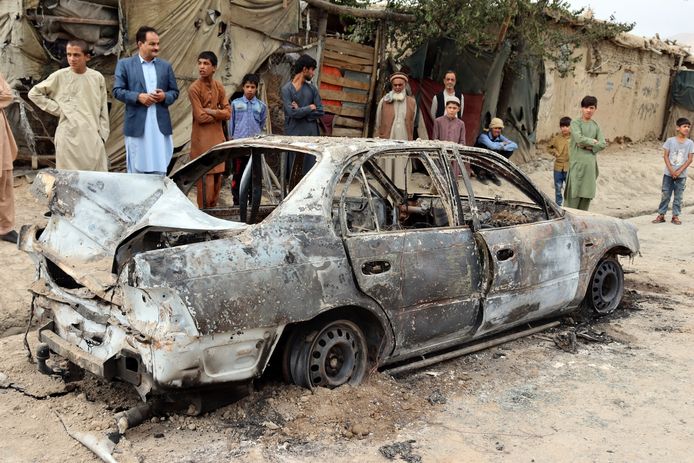 Des habitants voient un véhicule endommagé par une attaque à la roquette à Kaboul, Afghanistan, lundi 30 août 2021.