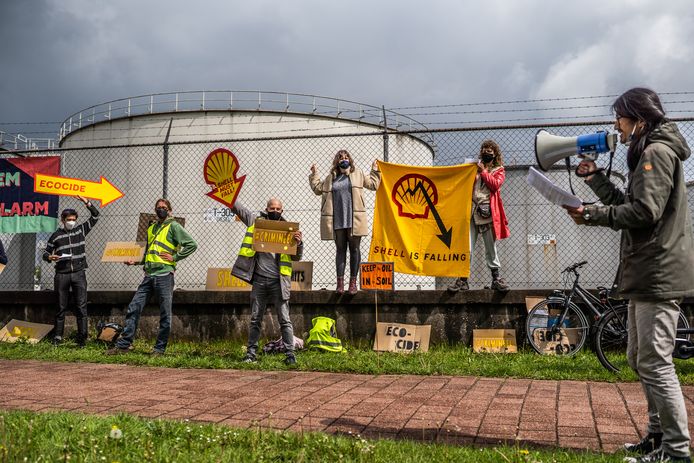 Actievoerder Erik Lu hanteert de megafoon bij de demonstratie bij Shell in Arnhem. ,,We staan vandaag stil bij de schade die Shell aanricht en nog van plan is om aan te richten tot elke druppel olie uit de grond is gehaald.”