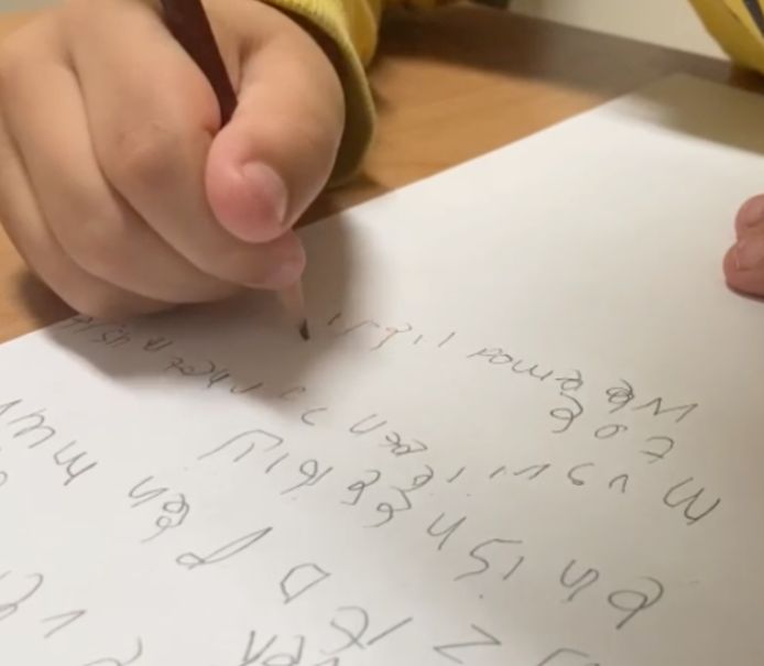 Een leerling uit groep 4 aan het schrijven. ,,Hij houdt het potlood met de vuist vast, op deze manier lukt het niet om kleine bewegingen of letters te maken”, aldus Overvelde.