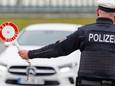 Een agent van de Duitse federale politie houdt een auto staande aan de grens.