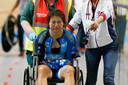 Een gehavende Xiaojuan Diao uit Hong Kong wordt na haar crash met een baancommissaris weggereden in een rolstoel. Het ongeluk gebeurde op de Omnium vrouwen tijdens de wereldkampioenschappen baanwielrennen in Apeldoorn. ANP/Bas Czerwinski