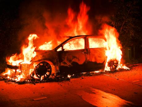 Auto in brand gestoken op grasveld met bomen in Riethoven, brandweer bereikt vuur met moeite