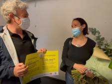 Alain Maron remet des fleurs à la femme qui a reçu la millionième dose de vaccin à Bruxelles