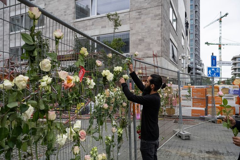 Er werden bloemen voor de slachtoffers aan het hek gehangen door collega's van de omgekomen bouwvakkers. Beeld Klaas De Scheirder