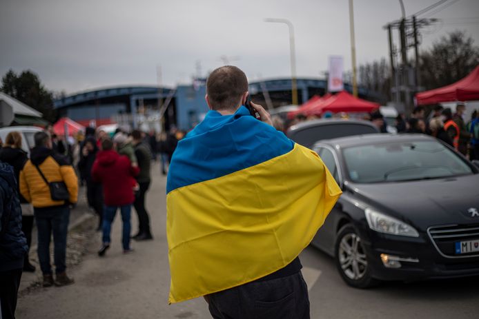 Een man met de Oekraïense vlag rond zich aan een grenspunt in Vysne Nemecke, Slovakije.