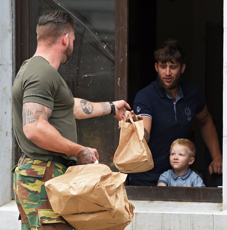 Een soldaat brengt eten naar een getroffen gezin in Pepinster. Beeld Photo News