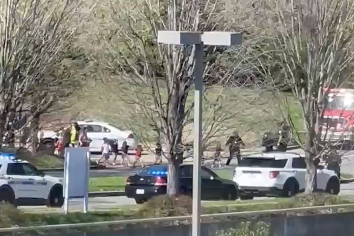 Officers and teachers lead children away from the Nashville school.