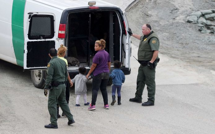 Medewerkers van de Amerikaanse douane- en grensautoriteit CBP pakken een vrouw en kinderen op bij de grens met Mexico.