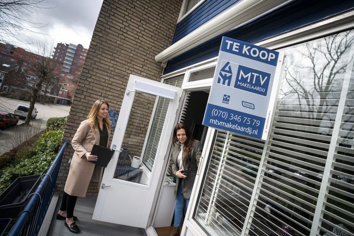 Een belangstellende wordt door een makelaar rondgeleid tijdens een bezichtiging van een woning in Den Haag.