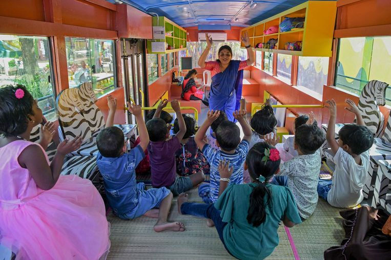 Een omgebouwde stadsbus doet nu dienst als crèche in de Zuid-Indiase stad Trivandrum. De organisatie Education on Wheels rijdt ermee naar buurten voor kinderen die anders geen onderwijs krijgen. Beeld AFP