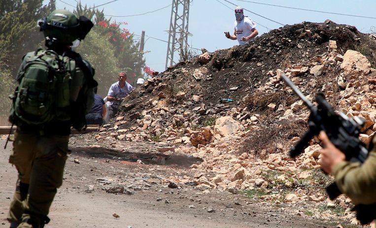Palestijnse demonstranten gooien stenen naar Israëlische troepen rond het dorp Kfar Qaddum, vlakbij Nablus. Beeld AFP