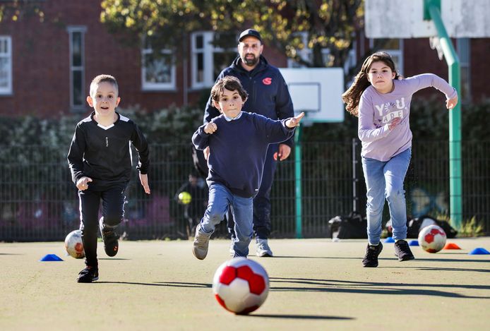 Trainer Hassan Amhayi geeft een voetbalclinic aan kinderen uit stadsdeel Segbroek
