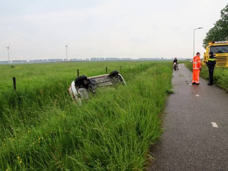Auto op zijn kop in de sloot door ongeval in Lienden