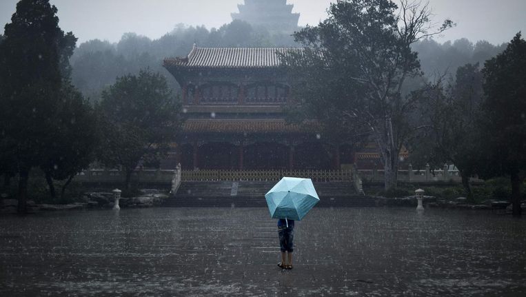 Een Chinese jongen in de regen. Beeld afp