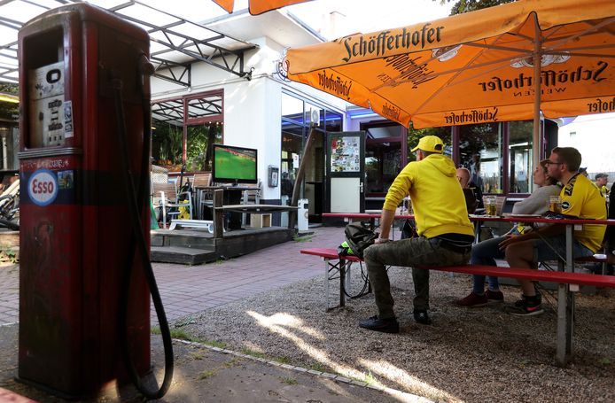 Borussia-fans volgen de wedstrijd op het terras van een café.