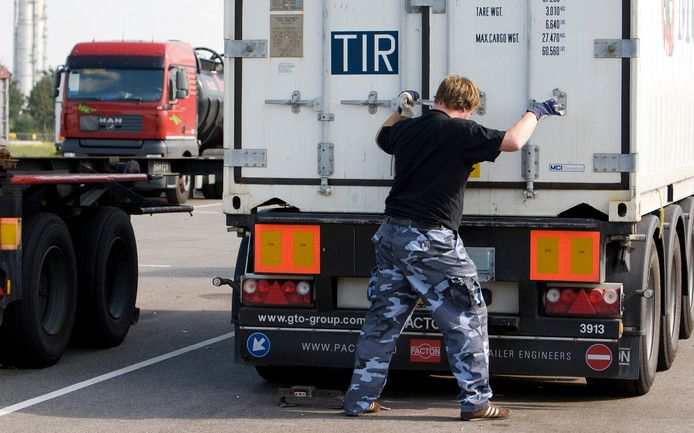 Een chauffeur sluit en verzegelt de laadklep van een container achterop zijn wagen. Foto ter illustratie.