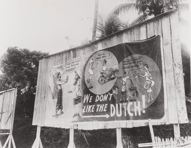 Straatbeeld met een paneel met anti-Nederlandse propaganda: 'We don't like the Dutch' op Java in toenmalig Nederlands-Indië, eind jaren veertig van de vorige eeuw. Beeld 