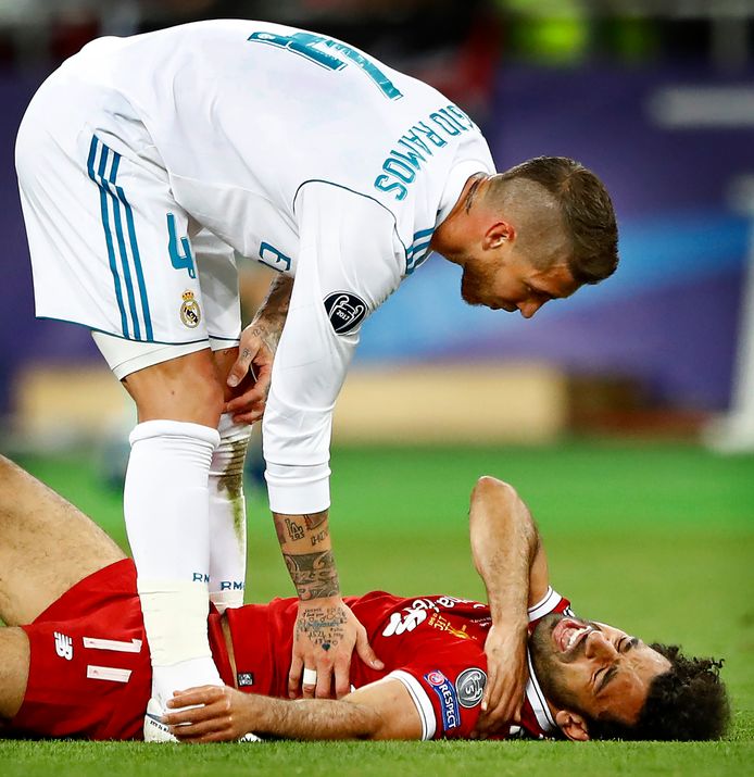 Sergio Ramos die zich bekommerd om Mohamed Salah die verkeerd op zijn arm terechtkomt en uitvalt.