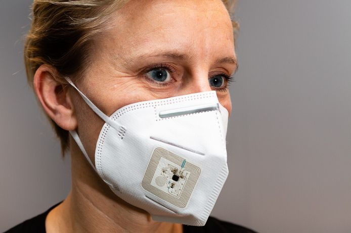 Een vrouw met een prototype van het masker dat werd ontwikkeld met sensoren die wasbaar en plooibaar zijn.