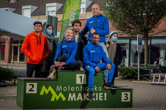 Op de foto zittend: Miranda Boonstra (Nijmeegse atlete), naast haar zittend: Gebreselasi Habtom en boven hem in het blauw Jeroen van Gisbergen. Ze worden omringd door de Afghaanse vluchtelingen die hebben meegeholpen als vrijwilliger