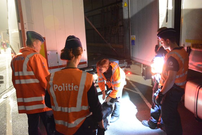 Een politieactie waarbij vrachtwagens worden onderzocht op mogelijke verstekelingen in Kruibeke.